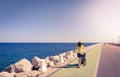 Mother strolling with newborn in a coast long road