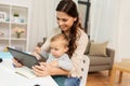 Mother student with baby and tablet pc at home Royalty Free Stock Photo