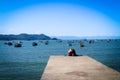 Mother and son sited embraced in a pier in Praia do Pereque, Guaruja, Brazil