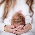 The mother supports the head of the baby lying on her lap Royalty Free Stock Photo