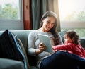 Mother, tablet and baby playing on sofa in living room for entertainment, bonding or time together at home. Happy mom Royalty Free Stock Photo