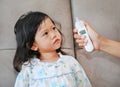 Portrait of child girl with a ear thermometer measuring Royalty Free Stock Photo