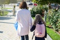 Mother taking child to school. Holding hands, background - autumn city. Royalty Free Stock Photo