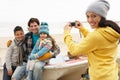 Mother Taking Family Photograph On Winter Beach