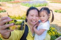 Mother taking photo with her daughter by phone