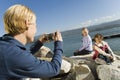 Mother taking picture of daughters at the lake Royalty Free Stock Photo