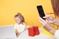 Mother taking picture of her daughter in process of online shopping on the laptop. Royalty Free Stock Photo