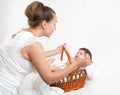 Mother talk with baby in basket on white towel, family concept Royalty Free Stock Photo