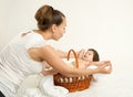 Mother talk with baby in basket on white towel, family concept, yellow toned Royalty Free Stock Photo