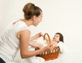 Mother talk with baby in basket on white towel, family concept, yellow toned Royalty Free Stock Photo