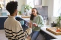 Mother Talking With Teenage Daughter At Home In Kitchen Drinking Hot Drinks Together Royalty Free Stock Photo