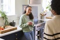 Mother Talking With Teenage Daughter At Home In Kitchen Drinking Hot Drinks Together Royalty Free Stock Photo