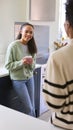 Mother Talking With Teenage Daughter At Home In Kitchen Drinking Hot Drinks Together Royalty Free Stock Photo