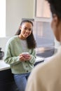 Mother Talking With Teenage Daughter At Home In Kitchen Drinking Hot Drinks Together Royalty Free Stock Photo