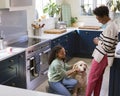 Mother Talking With Teenage Daughter Relaxing At Home In Kitchen With Pet Dog Royalty Free Stock Photo