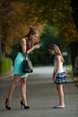 Mother talking to naughty girl on a street in park