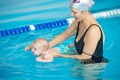 Mother teach her baby, how to swim in a swimming pool Royalty Free Stock Photo