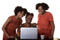 A mother or teacher looking at a computer with 2 teenagers