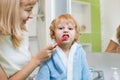 Mother teaches her son the brush his teeth in the bathroom Royalty Free Stock Photo