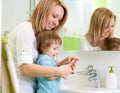 Mother teaches kid washing hands in bathroom Royalty Free Stock Photo