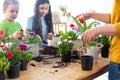 Mother teaches kids to take care of flowers and plants