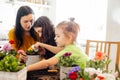 Mother teaches kids to take care of flowers and plants