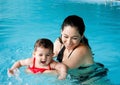 Mother teaching baby swimming Royalty Free Stock Photo