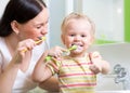 Mother teaching child teeth brushing