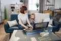 Mother teaching cute little musician girl to playing musical instruments.