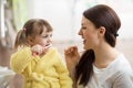 Mother teaching daughter child teeth brushing in bathroom