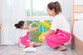 Mother teaching daughter cleaning their home . Family housework concept