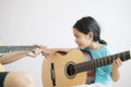 Mother teaching the daughter learning how to play acoustic classic guitar for jazz and easy listening song select focus Royalty Free Stock Photo