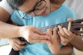 Mother teaching the daughter learning how to play acoustic classic guitar for jazz and easy listening song select focus shallow Royalty Free Stock Photo