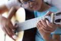 Mother teaching the daughter learning how to play acoustic classic guitar for jazz and easy listening song select focus shallow