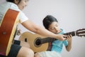 Mother teaching the daughter learning how to play acoustic classic guitar for jazz and easy listening song select focus shallow Royalty Free Stock Photo