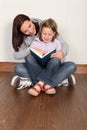 Mother teaching daughter to read home education