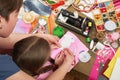 Mother teaching daughter to sew doll clothes, top view, sewing accessories top view, seamstress workplace, many object for needlew