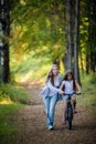 Mother teaching her daughter cycling in a forest outdoors Royalty Free Stock Photo