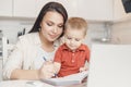 Mother teaching her kid son how to write pen. concept Online learning quarantine Royalty Free Stock Photo