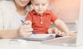 Mother teaching her kid son how to write pen. concept Online learning quarantine Royalty Free Stock Photo