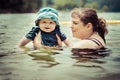 Mother teaching infant baby son to swim in lake Royalty Free Stock Photo