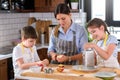 Mother making apple pie with children at home kitchen Royalty Free Stock Photo