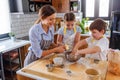 Mother making apple pie with children at home kitchen Royalty Free Stock Photo