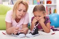 Mother teaching little girl to tie her shoes Royalty Free Stock Photo