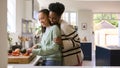 Mother With Teenage Daughter Helping To Prepare Meal At Home In Kitchen Together Royalty Free Stock Photo