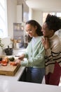 Mother With Teenage Daughter Helping To Prepare Meal At Home In Kitchen Together Royalty Free Stock Photo