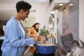 Mother With Teenage Daughter Helping To Prepare Meal At Home In Kitchen Together Royalty Free Stock Photo