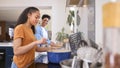 Mother With Teenage Daughter Helping To Prepare Meal At Home In Kitchen Together Royalty Free Stock Photo