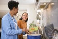 Mother With Teenage Daughter Helping To Prepare Meal At Home In Kitchen Together Royalty Free Stock Photo