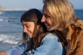 Mother and teenage daughter laughing by the mediterranean sea